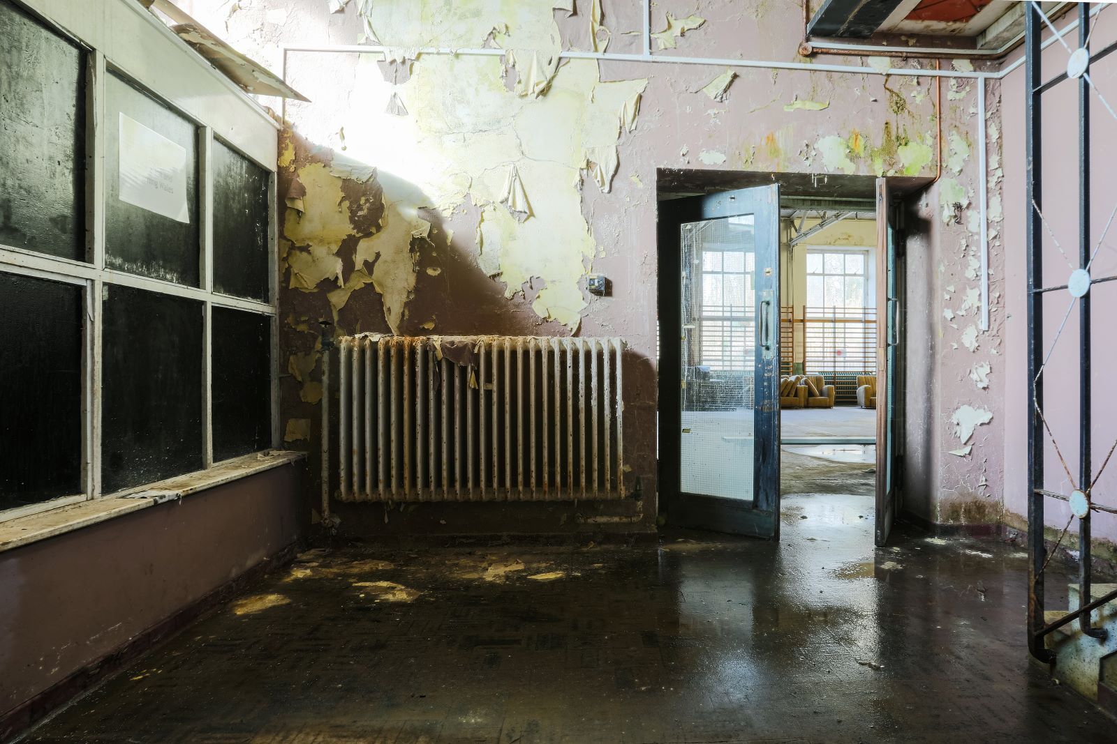 Room with peeling walls and damaged floor.jpg