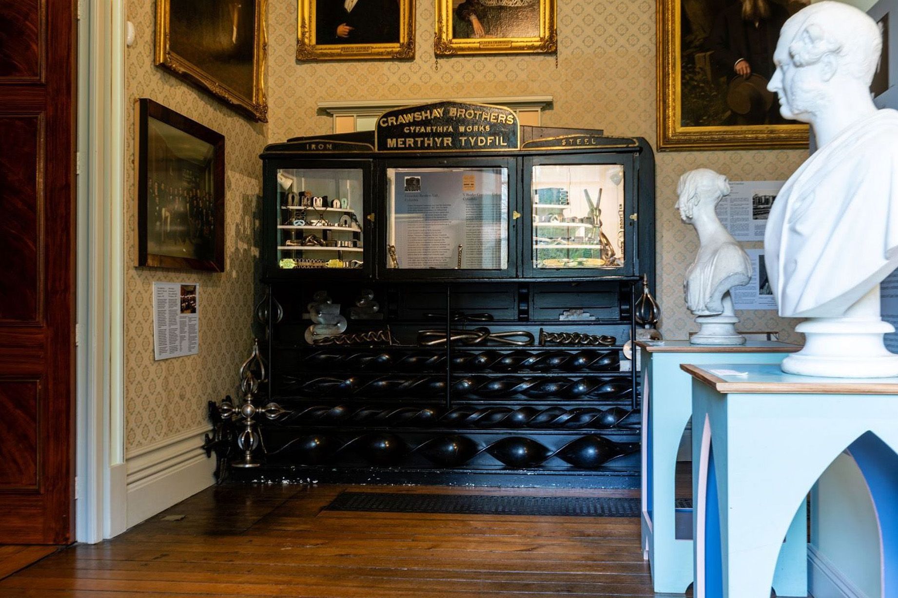 Black display case of iron and steel next to white bust statue.jpg